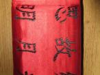 Daiktas Užrašų knygutė iš papiruso lapų, raudonais šilkiniais viršeliais su kiniškais hieroglifais.