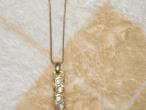 Daiktas aukso spalvos grandinele su pakabuku