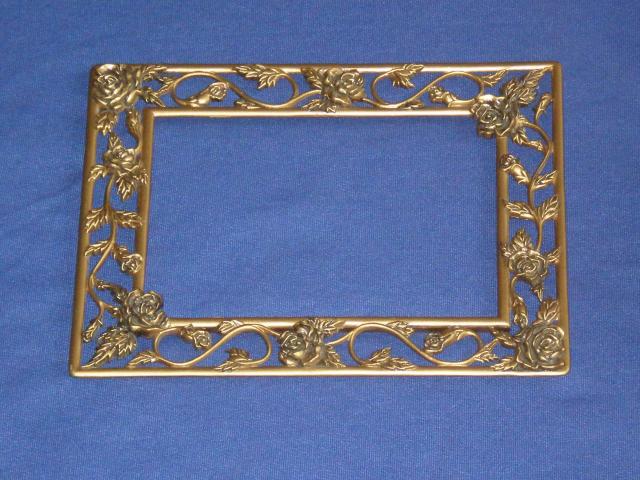 Daiktas Grazus metalinis (bronzinis?) remelis nuotraukai, paveiksleliui ar veidrodziui su geletu ornamentu